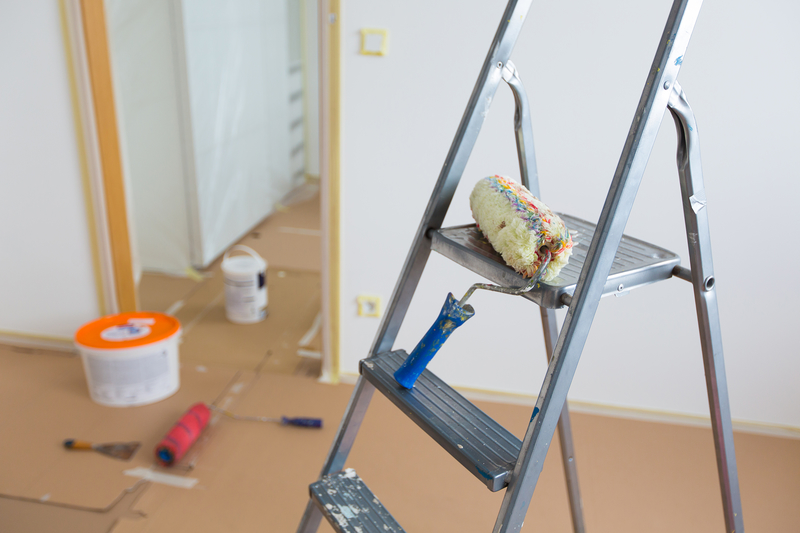 image of a metal ladder with a paint brush on the top step