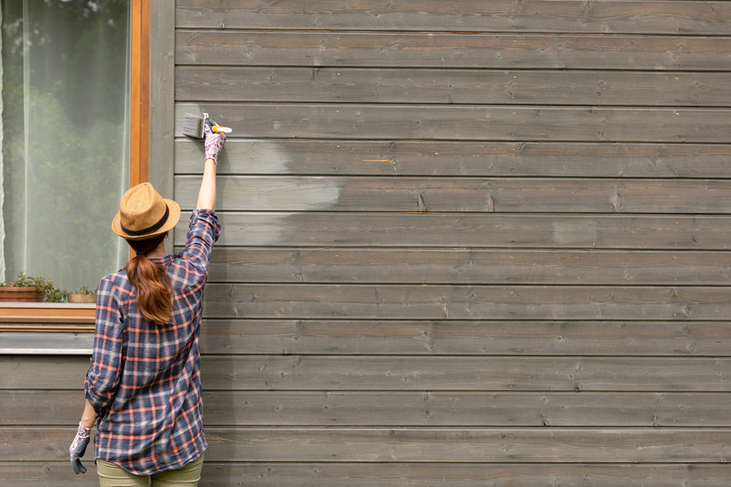 image of a woman painting home outside